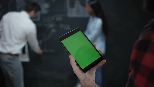 Young team in business startup, man holding tablet with green screen