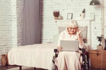 Smart handicap retired woman using laptop at home