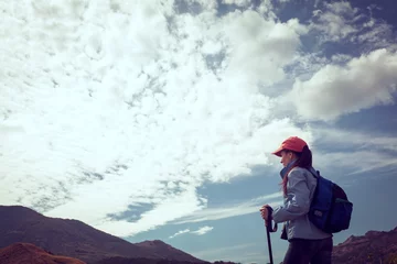 Fotobehang Woman Traveler with Backpack hiking in Mountains with beautiful summer landscape on background mountaineering sport lifestyle concept © 6okean