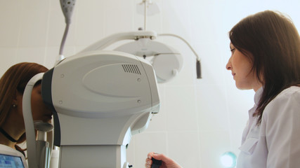 Ophthalmologist in eyes clinic doing diagnostic with vision for patient - high healthcare technology in medicine, close up