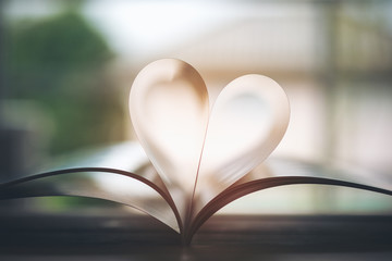 Open book with pages forming heart shape with feeling love and romance