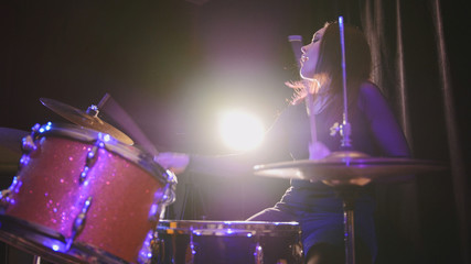 Attractive young girl rock musician - female drummer performing