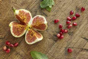 Fresh figs and pomegranate cut into four pieces. Overhead, top view.