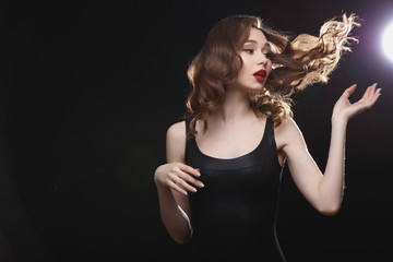 Beautiful young woman with flying hair and red lips