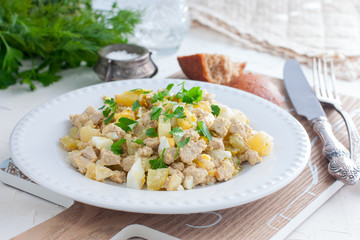 Salad with pollock liver, eggs, potatoes and cucumber, selective focus