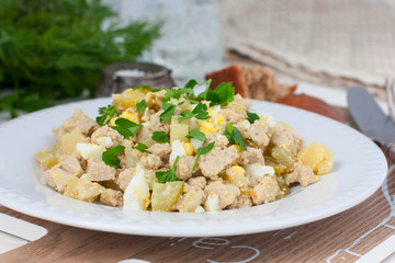 Salad with pollock liver, eggs, potatoes and cucumber, selective focus