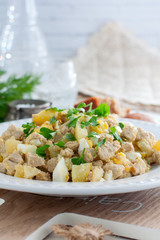 Salad with pollock liver, eggs, potatoes and cucumber, selective focus