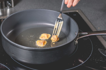 Cook frying chicken in a pan of oil