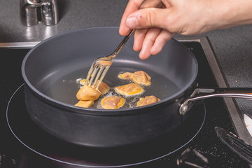 Cook frying chicken in a pan of oil