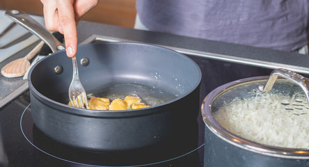 Cook frying chicken in a pan of oil