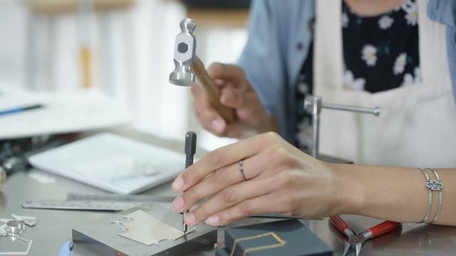  Jewelry designer working in studio, creating unique handmade pieces. 