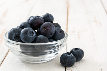 Blueberries in crystal bowl on white wooden background
