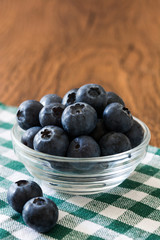 Blueberries in crystal bowl on wooden background
