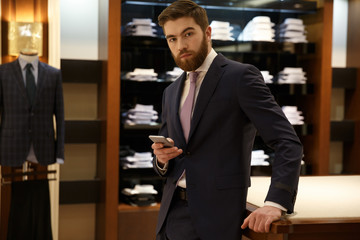 Man in suit holding smartphone