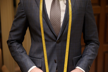 Cropped image of man with measuring tape on neck