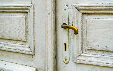 Old white door with golden doorknob
