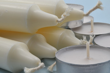 White candles on light blue background.