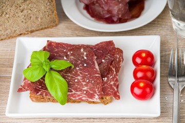 Scheibe Brot mit Bresaola Rinderschinken