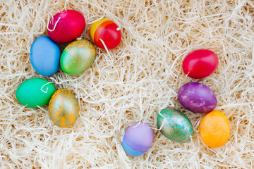 Fototapeta na wymiar Easter colored eggs on the hay