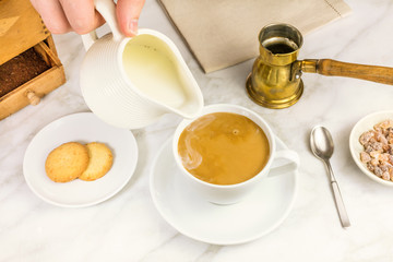 Milk just poured into cup of coffee
