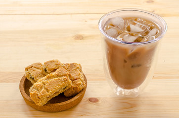 Apple strudel crispy pies and ice coffee on wood background.