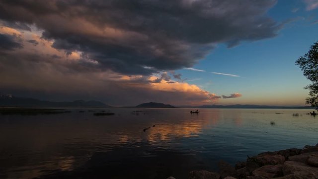 Time-lapse during sunset on Utah Lake with a boat moving through the water.
