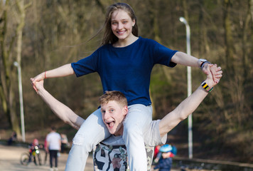 Fototapeta premium Happy smiling teen couple is having fun in the park, freedom concept