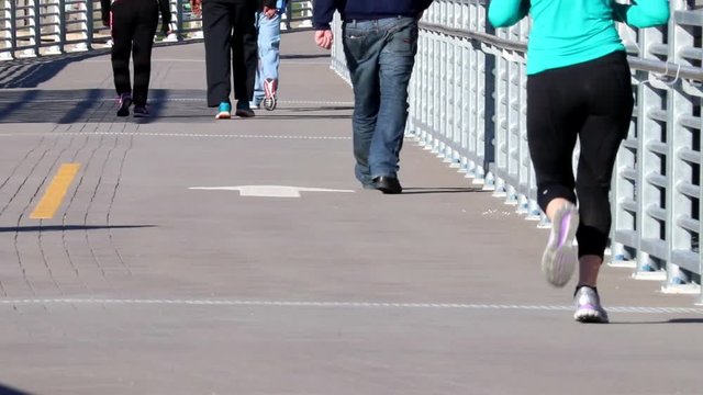 People jogging and exercising on bike path in slowmo