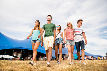 Teenagers at summer music festival in front of big blue tent