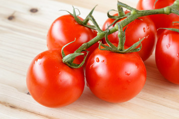 Bunch of fresh organic tomatoes on a wooden background