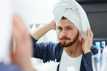 Man looking in mirror after washing hair