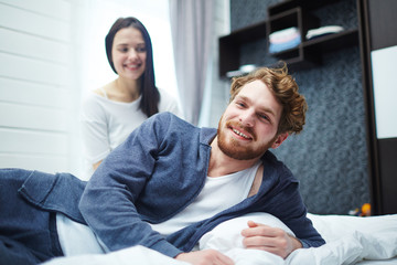 Cheerful man and his wife enjoying home rest