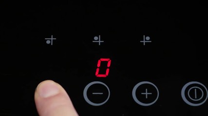 Induction stove. Woman starts cooking