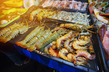 Variety of grilled seafood in Kota Kinabalu night market in Kota Kinabalu, Sabah Borneo, Malaysia. Selective focus, shallow DOF.