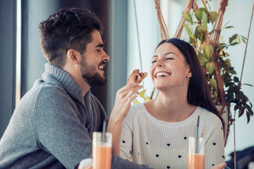 Happy young couple having breakfast in cafe