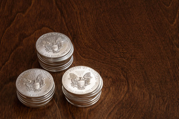 Stacks of American silver dollars on a wood background
