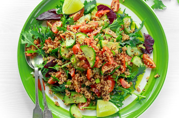 Quinoa tabbouleh salad with tomatoes, cucumber green onion. Concept healthy food