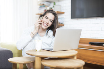 Young beautiful woman sitting on the floor working on laptop. Morning scene