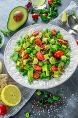 Quinoa tabbouleh salad with avocado, tomatoes, cucumber, green onion. Concept healthy food.