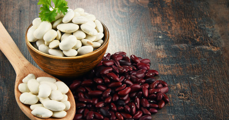 Composition with bowl of beans on wooden table