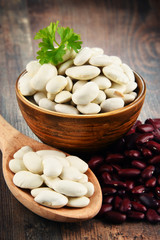 Composition with bowl of beans on wooden table