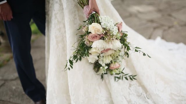 Wedding bridal bouquet of roses, lisianthus, lavender, Gypsophila, Verdure (Italian) in the hands of the bride. Wedding in Croatia, Dubrovnik.