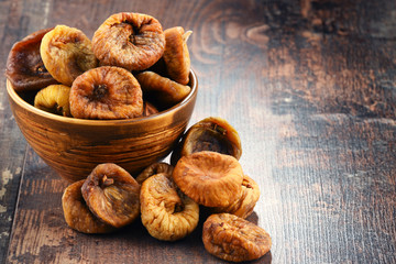 Composition with bowl of dried figs on wooden table - obrazy, fototapety, plakaty