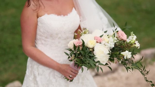 Wedding bridal bouquet of roses, lisianthus, lavender, Gypsophila, Verdure (Italian) in the hands of the bride. Wedding in Croatia, Dubrovnik.