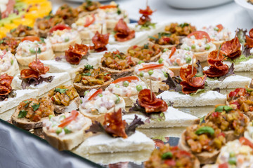 Colorful canape with vegetables and sausage on a slate plate