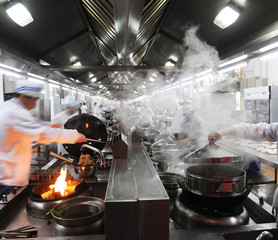 Motion chefs in a Chinese restaurant kitchen.
