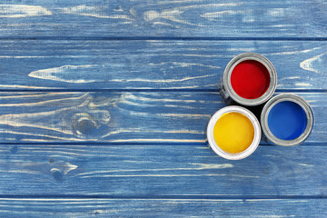 Red yellow and blue paint in jars on a blue chalkboard stand