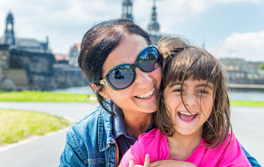 Mother and daughter smiling while visiting ancient european city