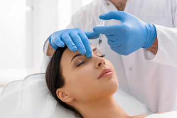 Serene woman receiving injection in face