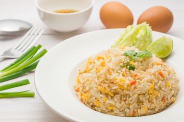 Fried rice with spicy sauce on white wooden background